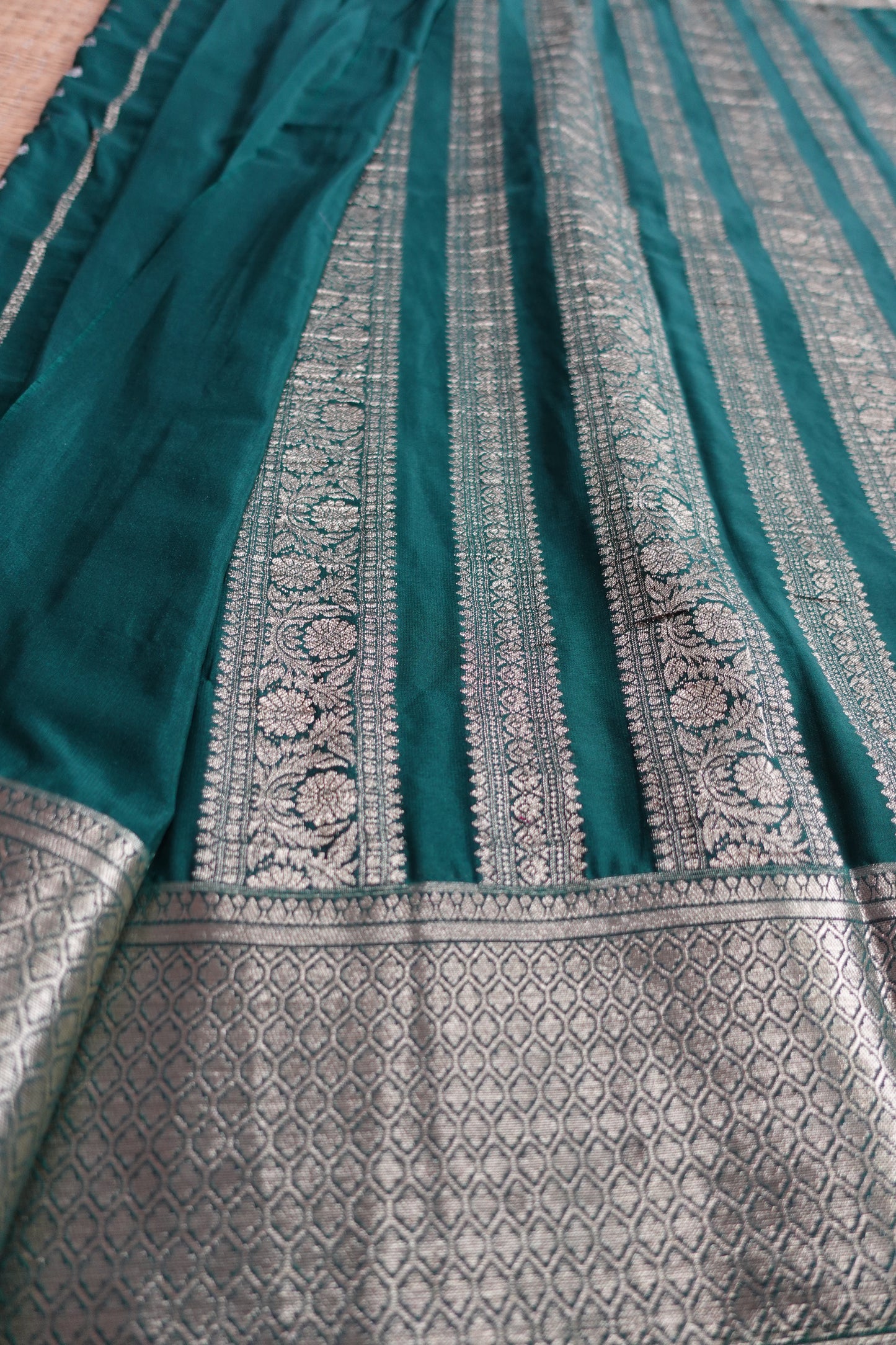 A bottle green colored crepe saree with 4-inch golden zari weaving (MCAUG131)