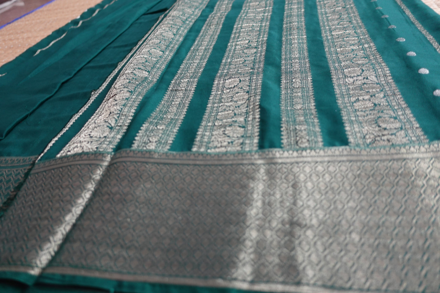 A bottle green colored crepe saree with 4-inch golden zari weaving (MCAUG131)